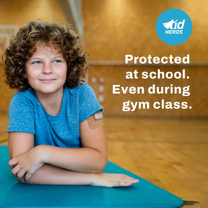 Child with a bandage on their arm in a gym setting, with t1dHEROS branding.