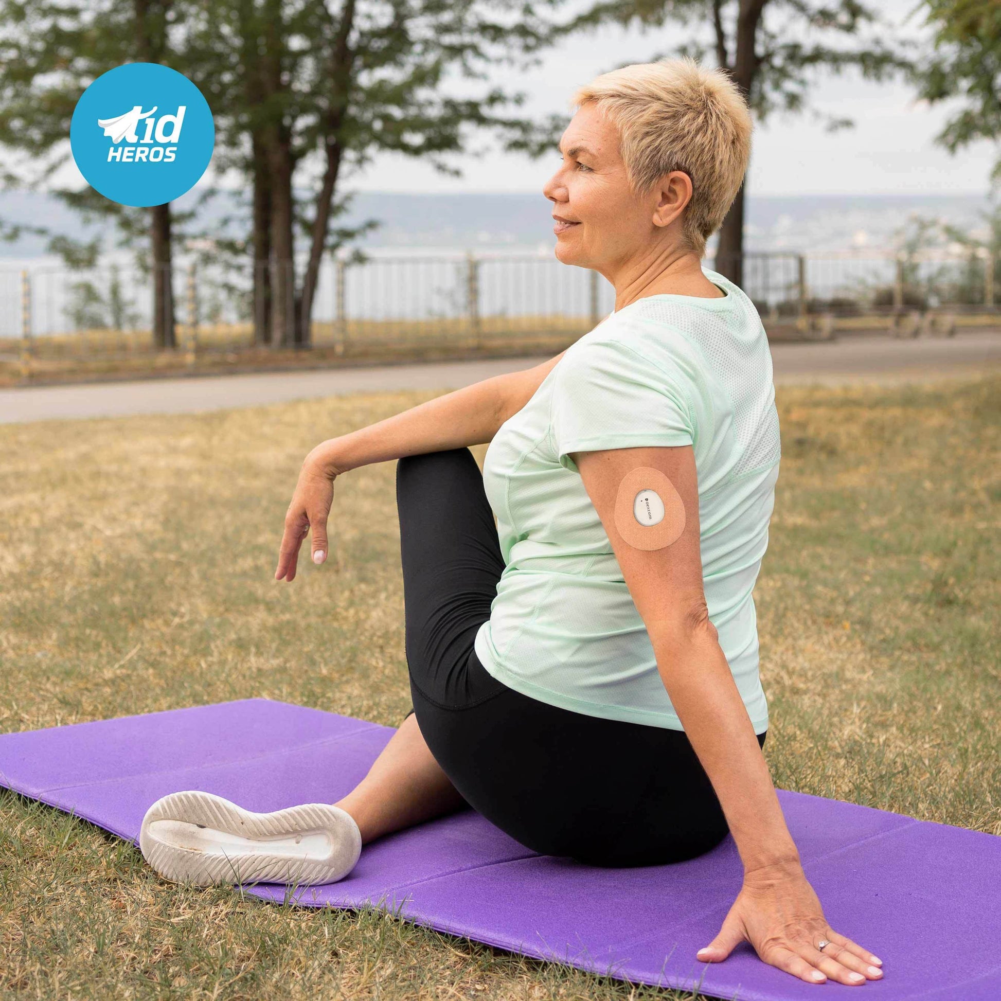 Woman sitting on a purple mat outdoors with a scenic background